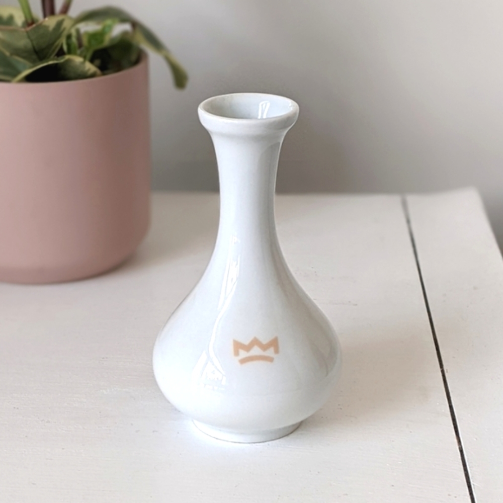 small white bud vase with crown insignia